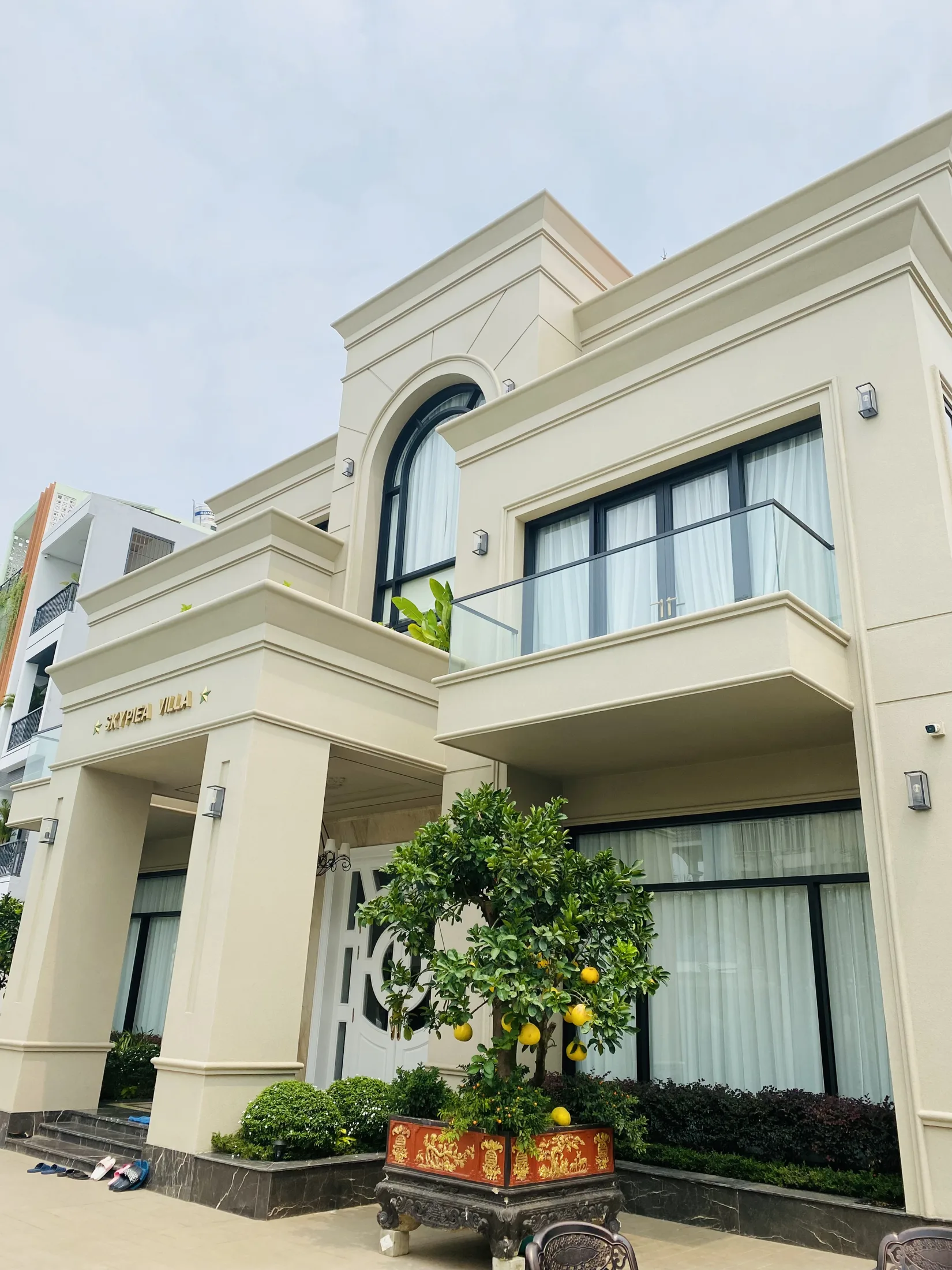 Lối vào Pool Villa Skypiea với hệ cột vuông, cửa sổ vòm và cây cảnh